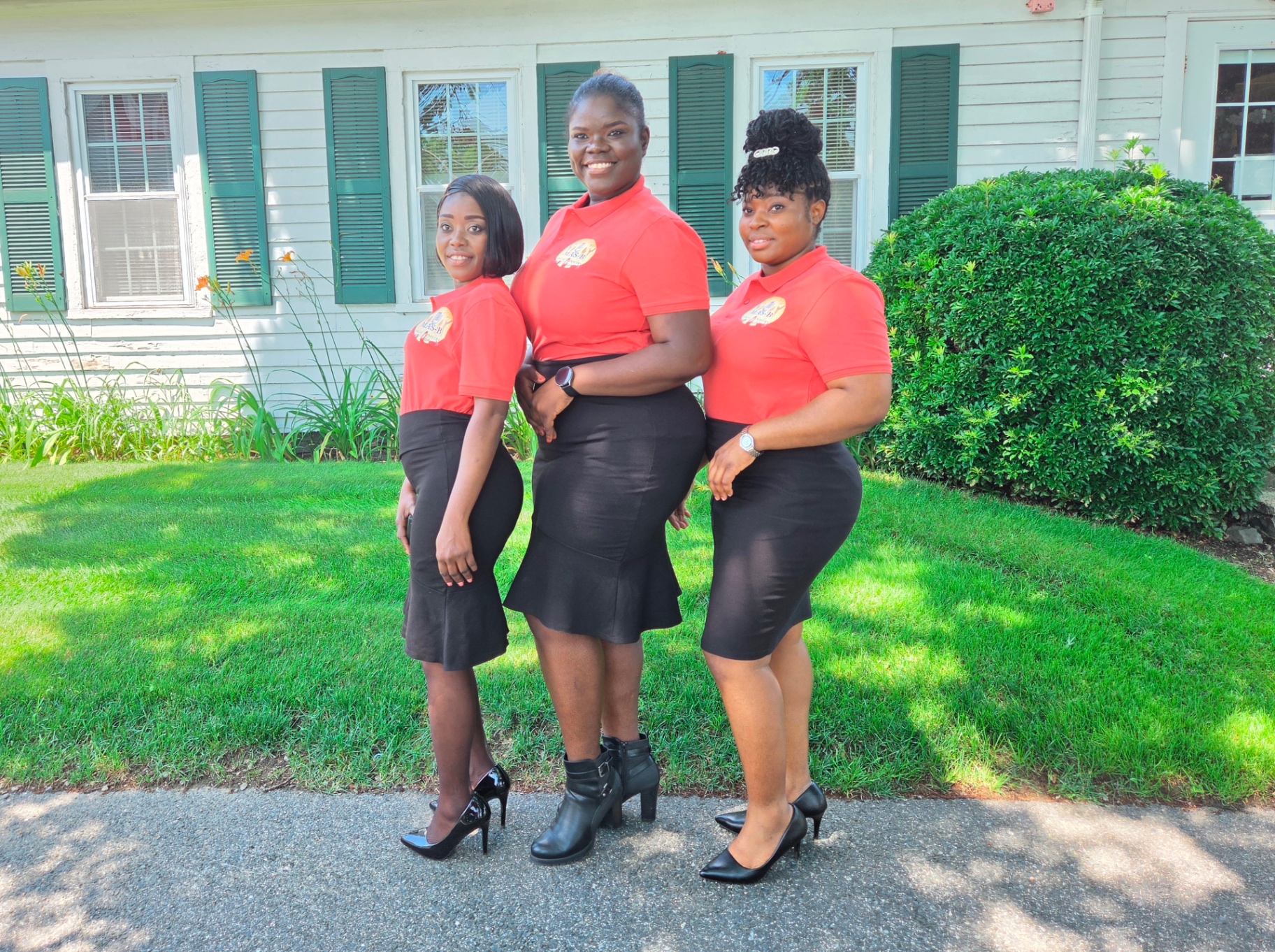 Three MAS-B Vocal Ministry members in red ministry polos standing together outdoors