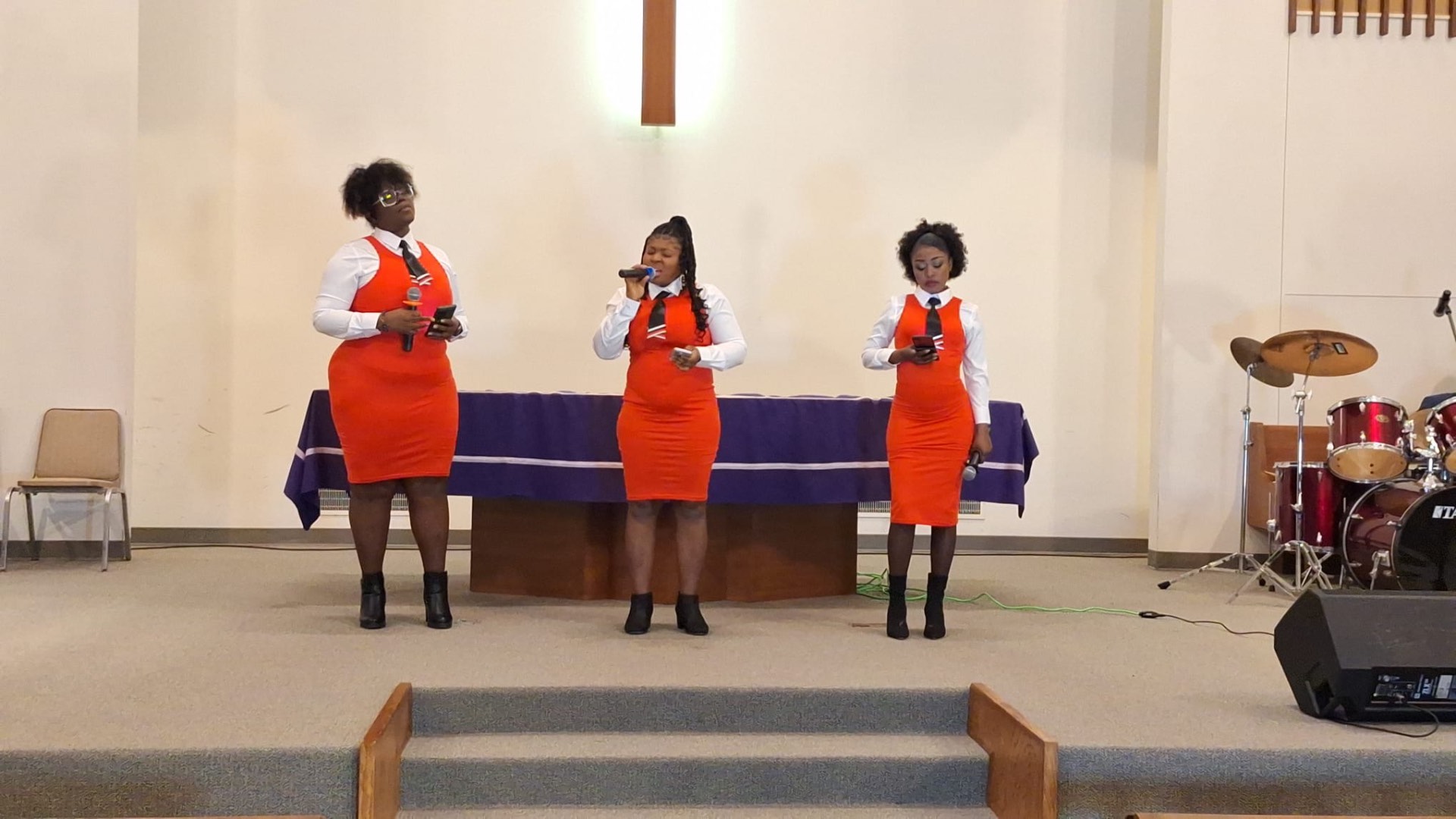 MAS-B Vocal Ministry trio singing in red dresses in a church sanctuary