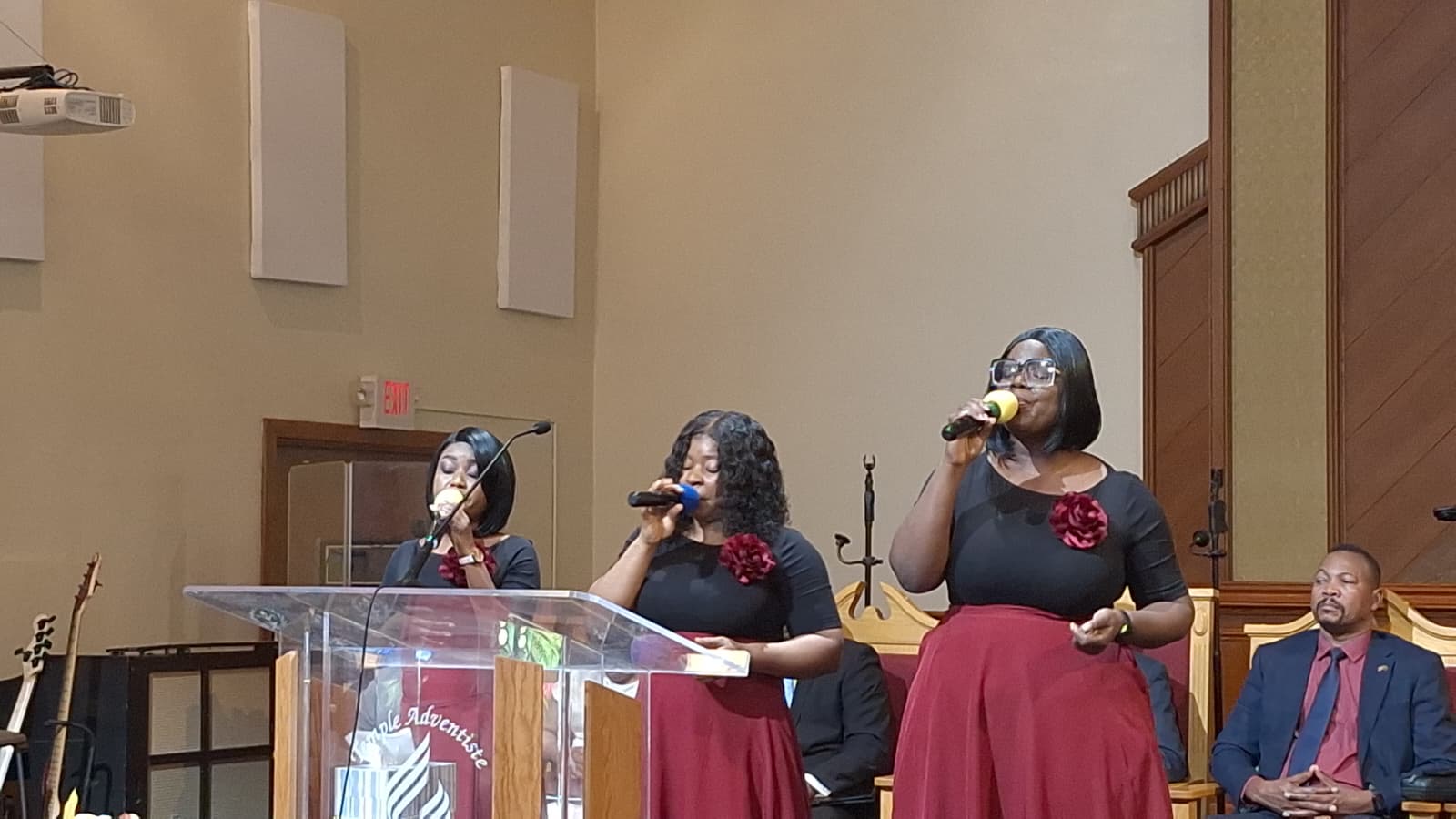MAS-B Vocal Ministry singing at a Seventh-day Adventist church podium in burgundy skirts