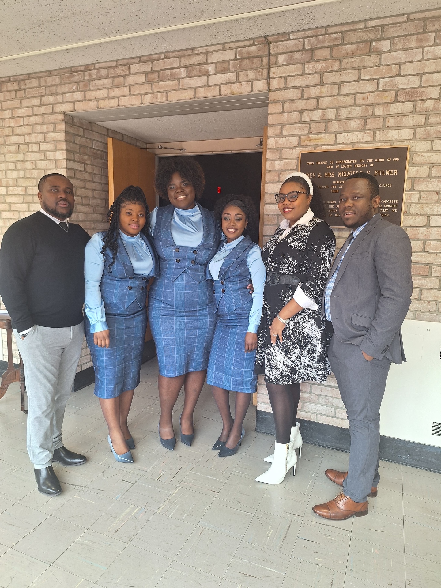 MAS-B Vocal Ministry members and hosts gathered by the chapel dedication plaque