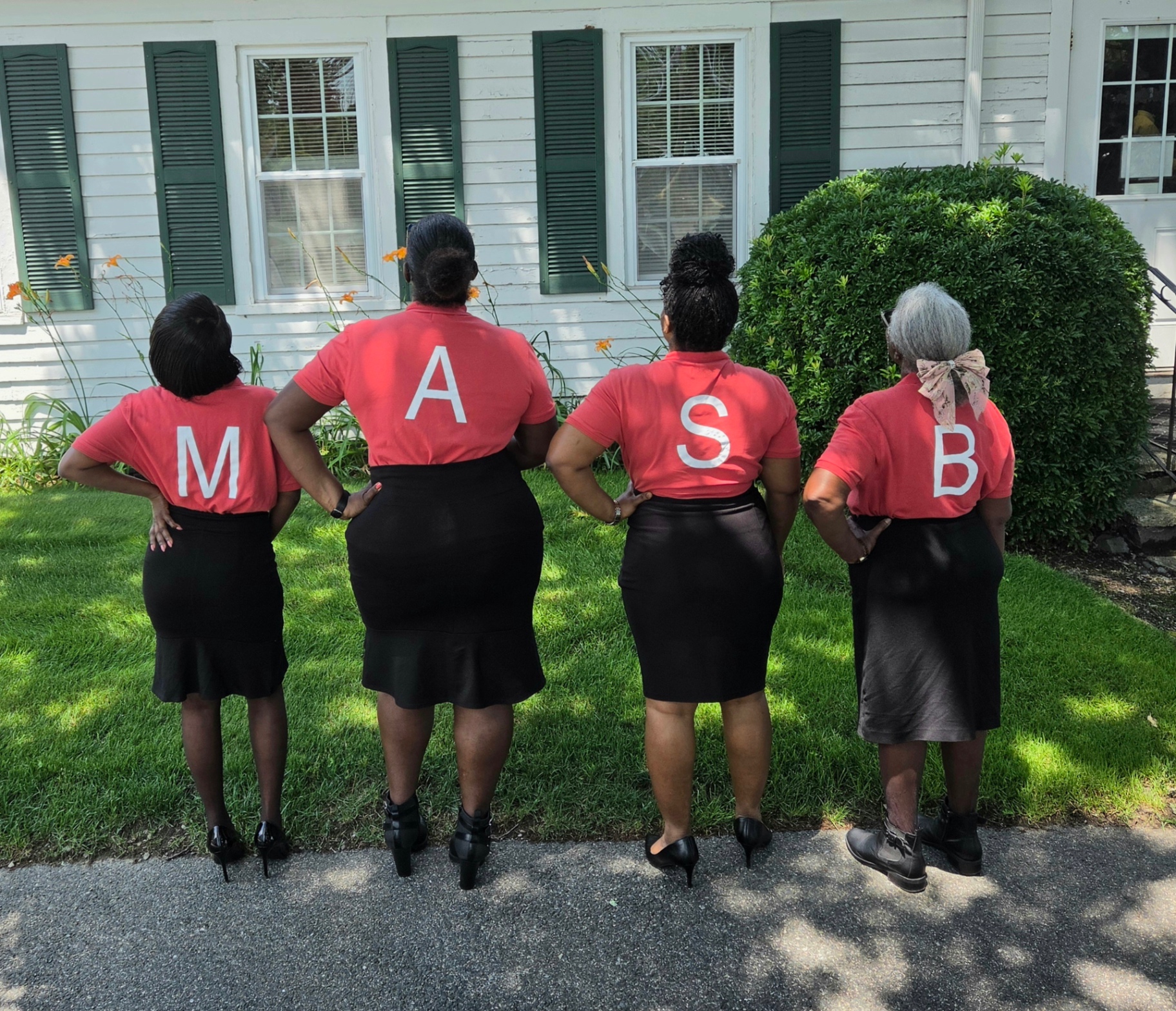 Four MAS-B members spelling out M A S B on the backs of their ministry shirts